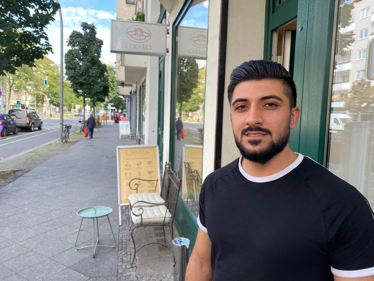 Mohamed Rachid, who immigrated to Germany in 2015, outside the barbershop where he is a trainee.