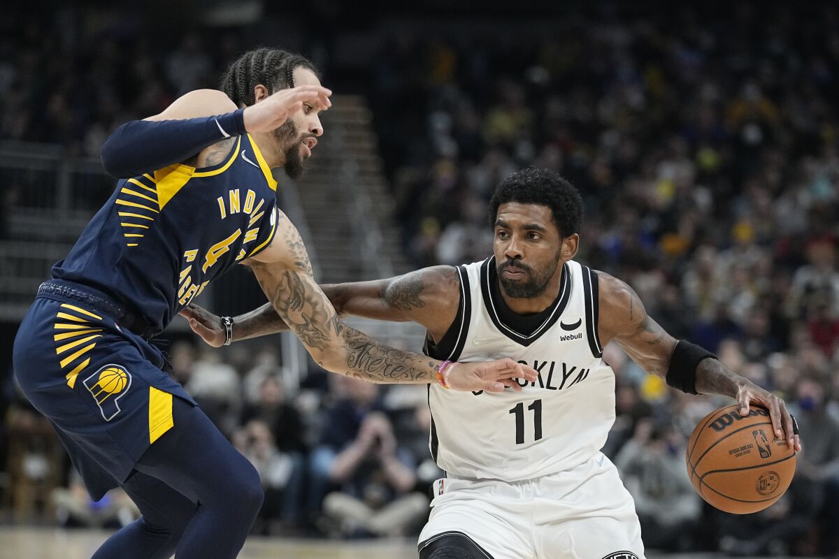 Brooklyn Nets' Kyrie Irving (11) is defended by Indiana Pacers' Duane Washington Jr. (4) during the first half of an NBA basketball game Wednesday, Jan. 5, 2022, in Indianapolis. (AP Photo/Darron Cummings)