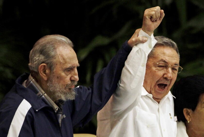 FILE - In this April 19, 2011 file photo, Fidel Castro, left, raises the hand of his brother President Raul Castro as they sing the international socialism anthem during the 6th Communist Party Congress in Havana, Cuba. For most of his life, Raul Castro played second-string to his brother, but for the past decade, it’s Raul who's been the face of communist Cuba. On Friday, April 16, 2021, Raul Castro formally announced he'd step down as head of the Communist Party, leaving Cuba without a Castro in an official position of command for the first time in more than six decades. (AP Photo/Javier Galeano, File)