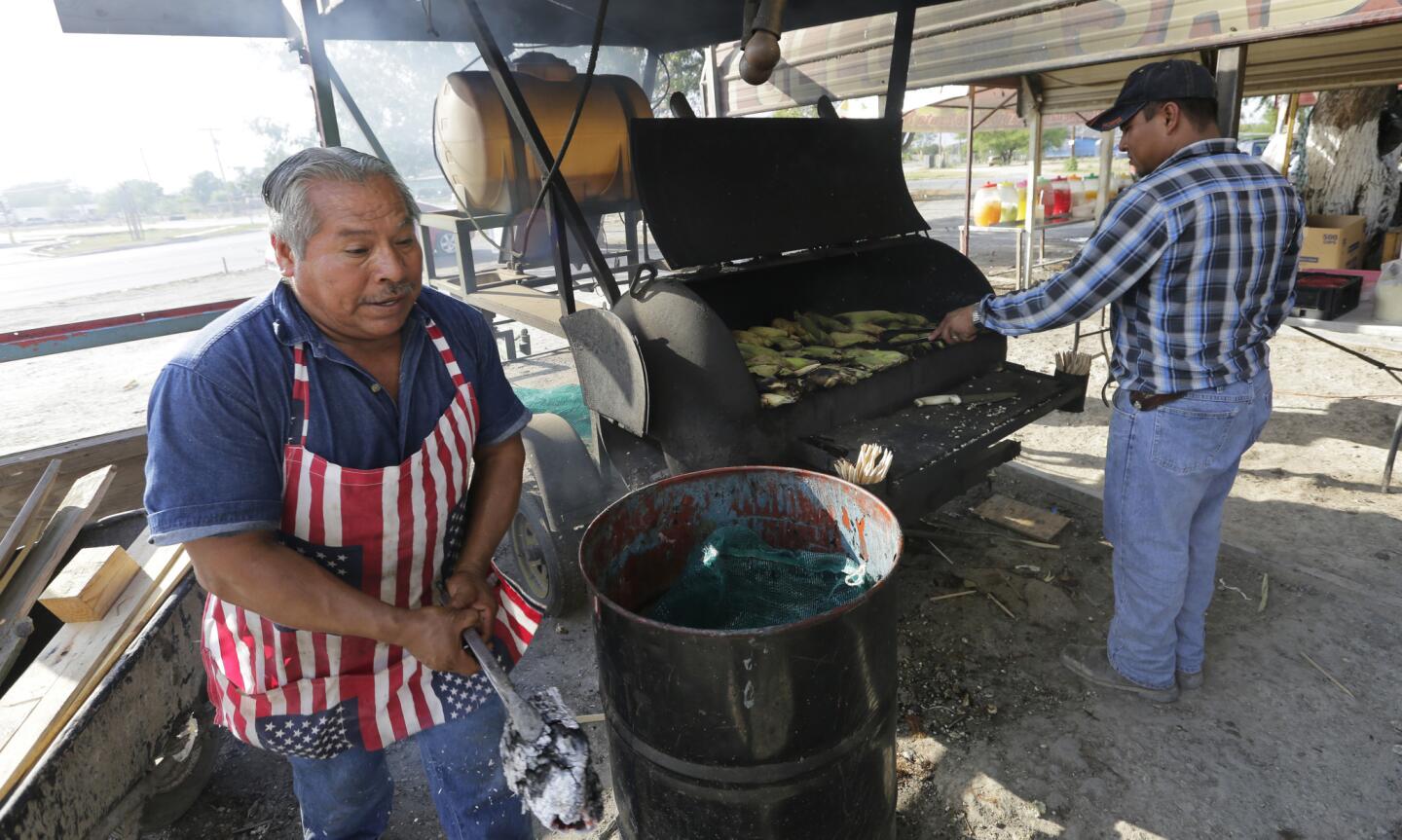 Dos personas cocinan maíz en un puesto callejero en la colonia South Tower de Alamo, Texas. Medio millón de personas, casi todas inmigrantes hispanos, viven en barrios pobres llamados colonias del lado estadounidense de la frontera con México.