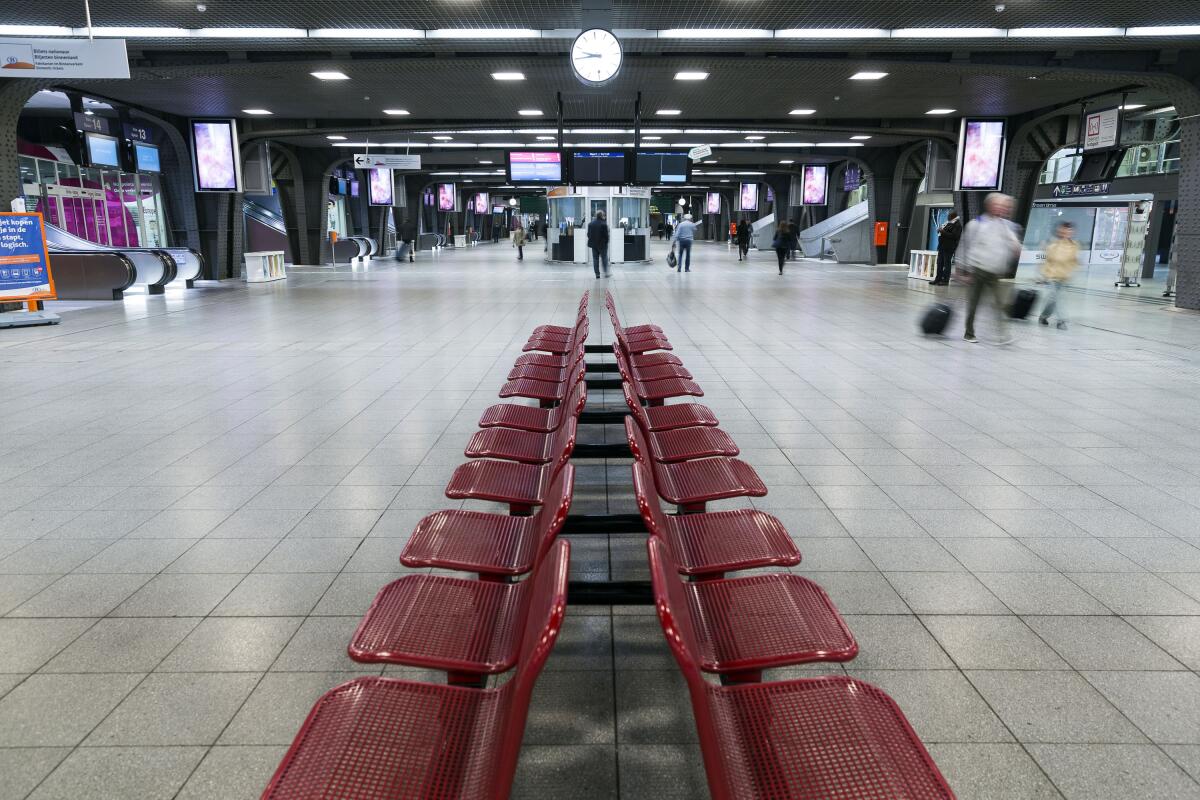 Passengers walk through a quiet Brussels Midi Station during a train strike