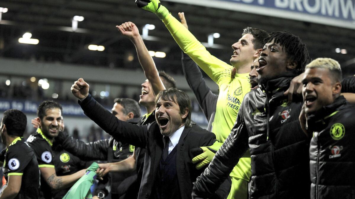Manager Antonio Conte (in suit) celebrates with Chelsea players after clinching the Premier League title with a 1-0 win at West Brom on Friday night.