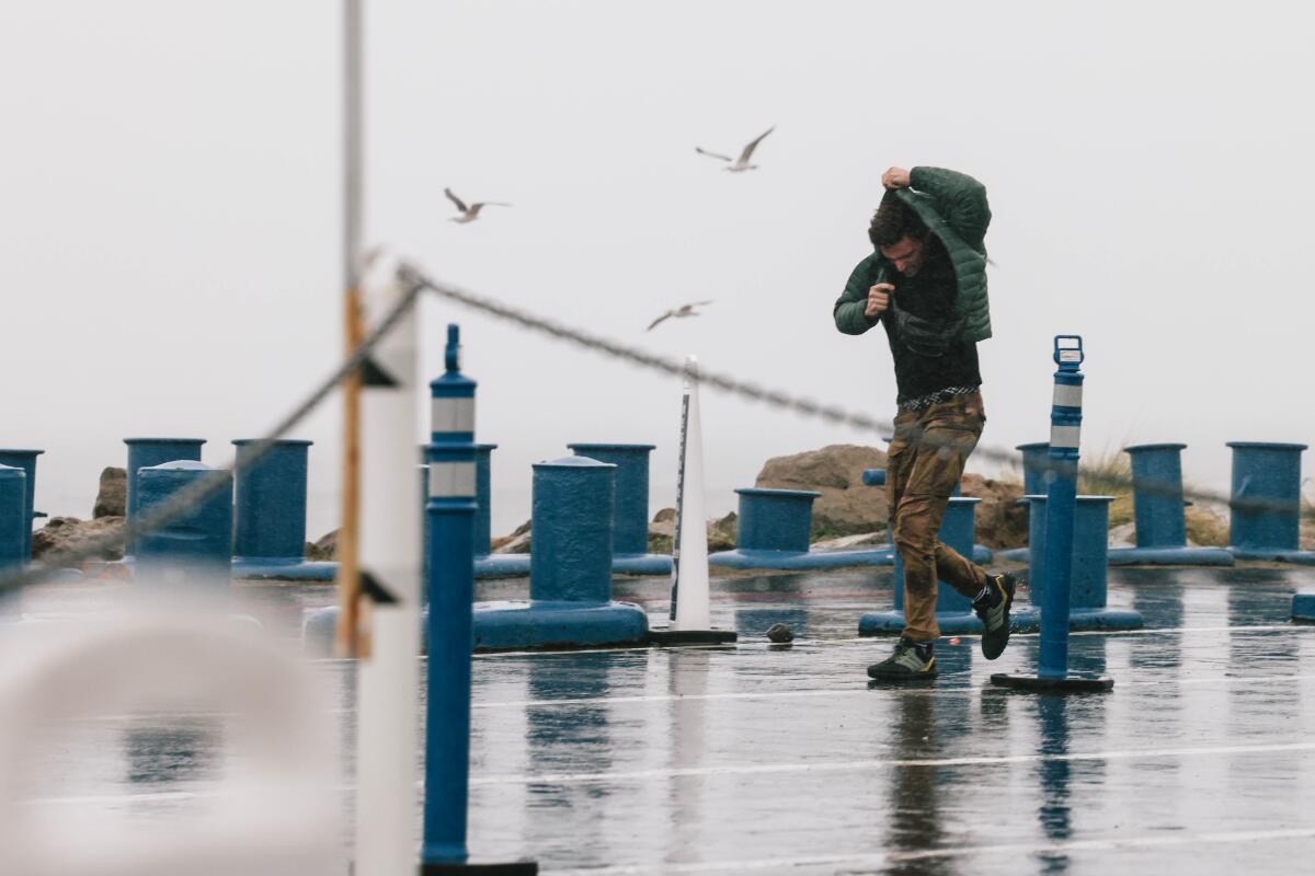 A person hurries and covers their head in the rain.
