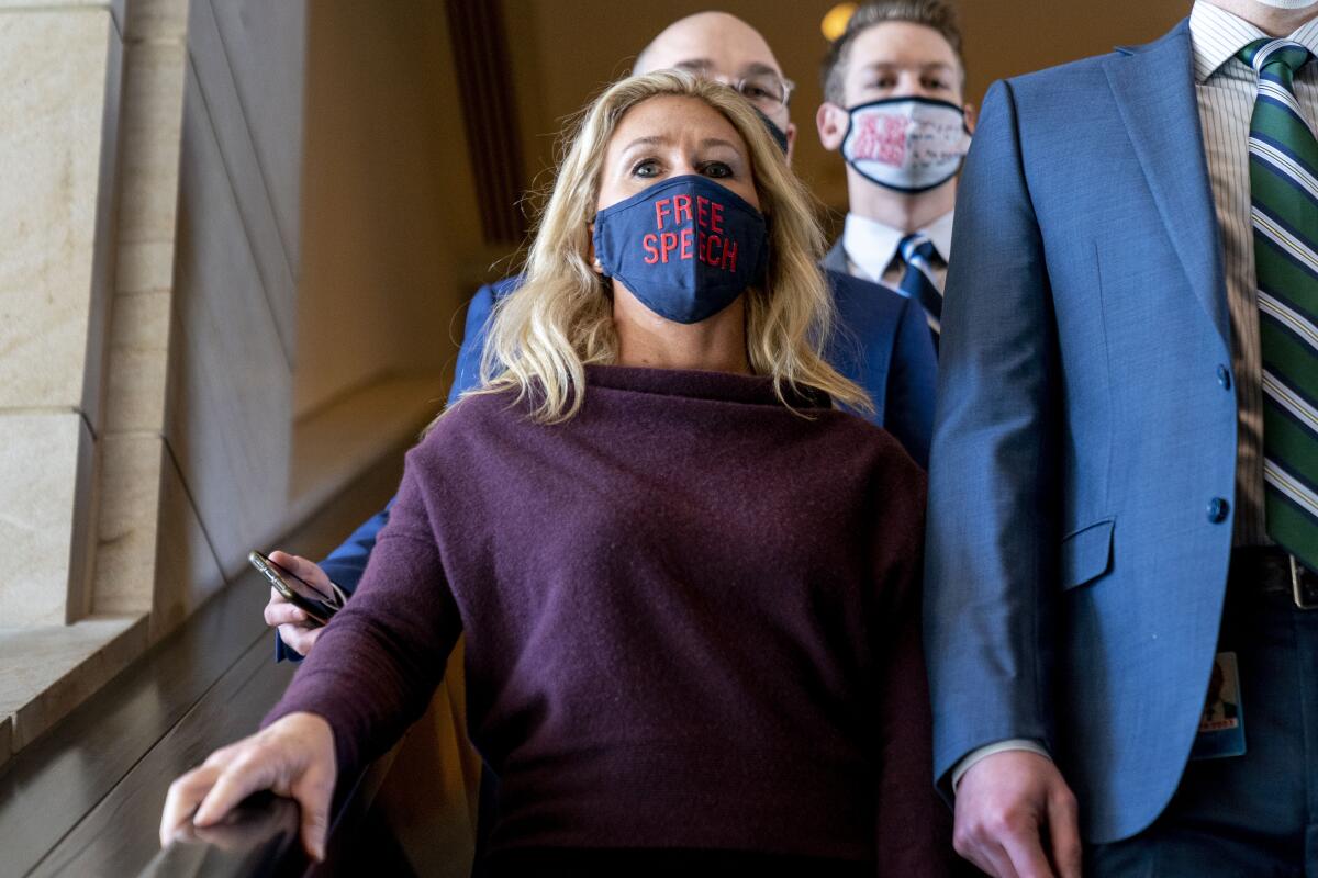Rep. Marjorie Taylor Greene wears a mask with the words 'free speech' on it.