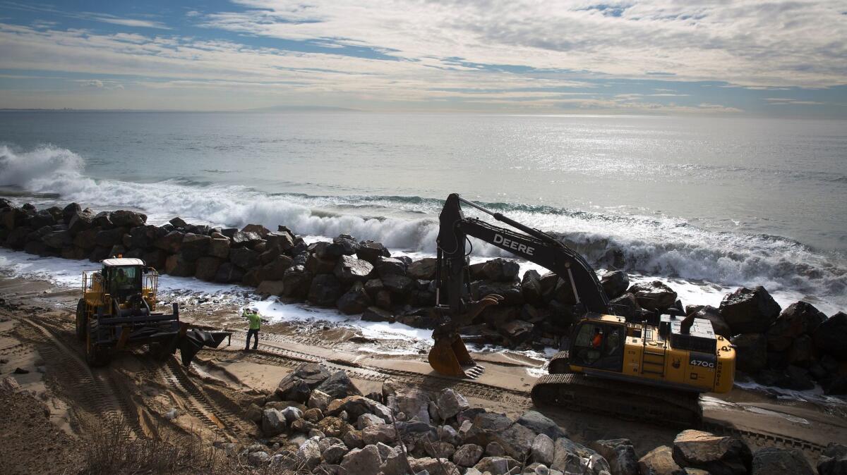 Caltrans contractor Nordic Industries works on constructing a rock barrier against erosion from tidal forces near Las Tunas Beach along Pacific Coast Highway in Malibu.