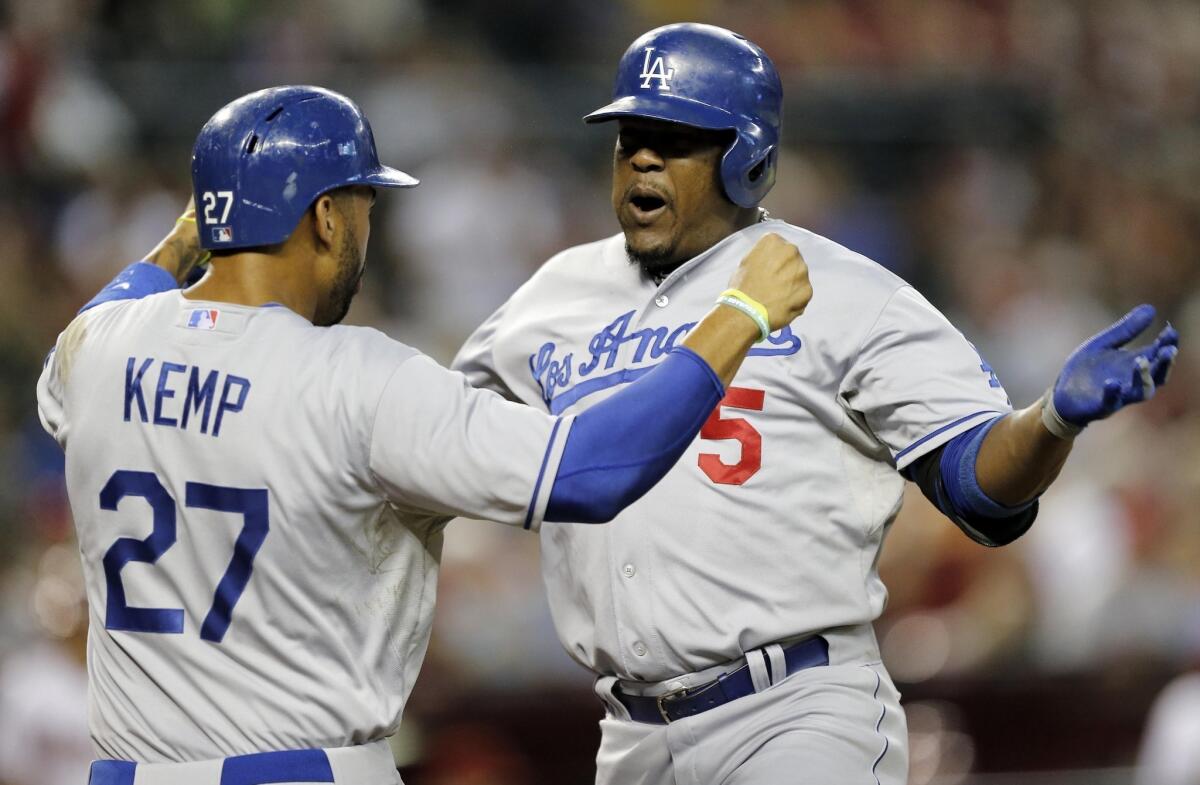 Dodgers third baseman Juan Uribe, right, is congratulated by teammate Matt Kemp after hitting a two-run home run in the first inning of the Dodgers' 9-3 win over the Arizona Diamondbacks on Tuesday night.