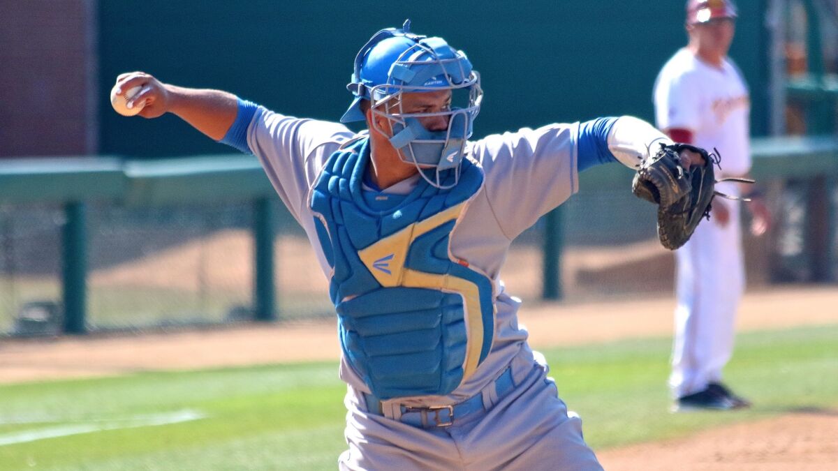 UCLA catcher Darrell Miller Jr. throws to first during a game against USC in April.