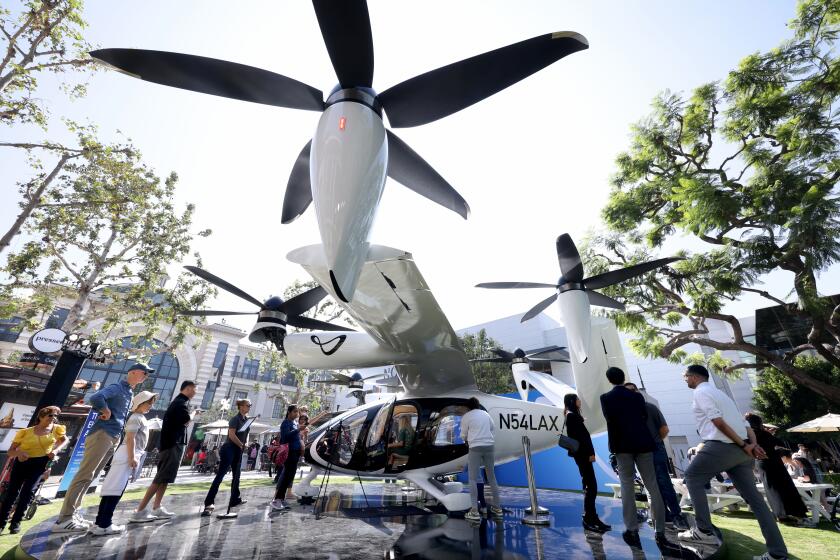 LOS ANGELES, CA - - SEPTEMBER 26, 2024 - People observe check out the flying taxi created by Joby Aviation at The Grove in the Fairfax District in Los Angles on September 25, 2024. Joby Aviation, Inc., is one of a handful of companies racing to be the first to make flying taxis a reality in Los Angeles. The California-based transportation company has developed the all-electric, vertical take-off and landing air taxi which it intends to operate as part of a fast, quiet, and convenient service in cities around the world. (Genaro Molina / Los Angeles Times)
