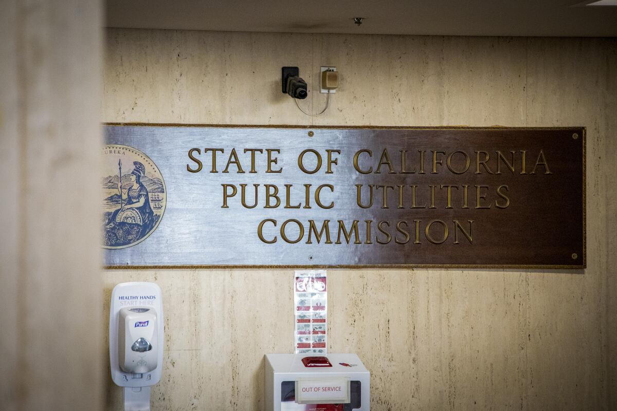 A sign says "State of California Public Utilities Commission" on a wall.