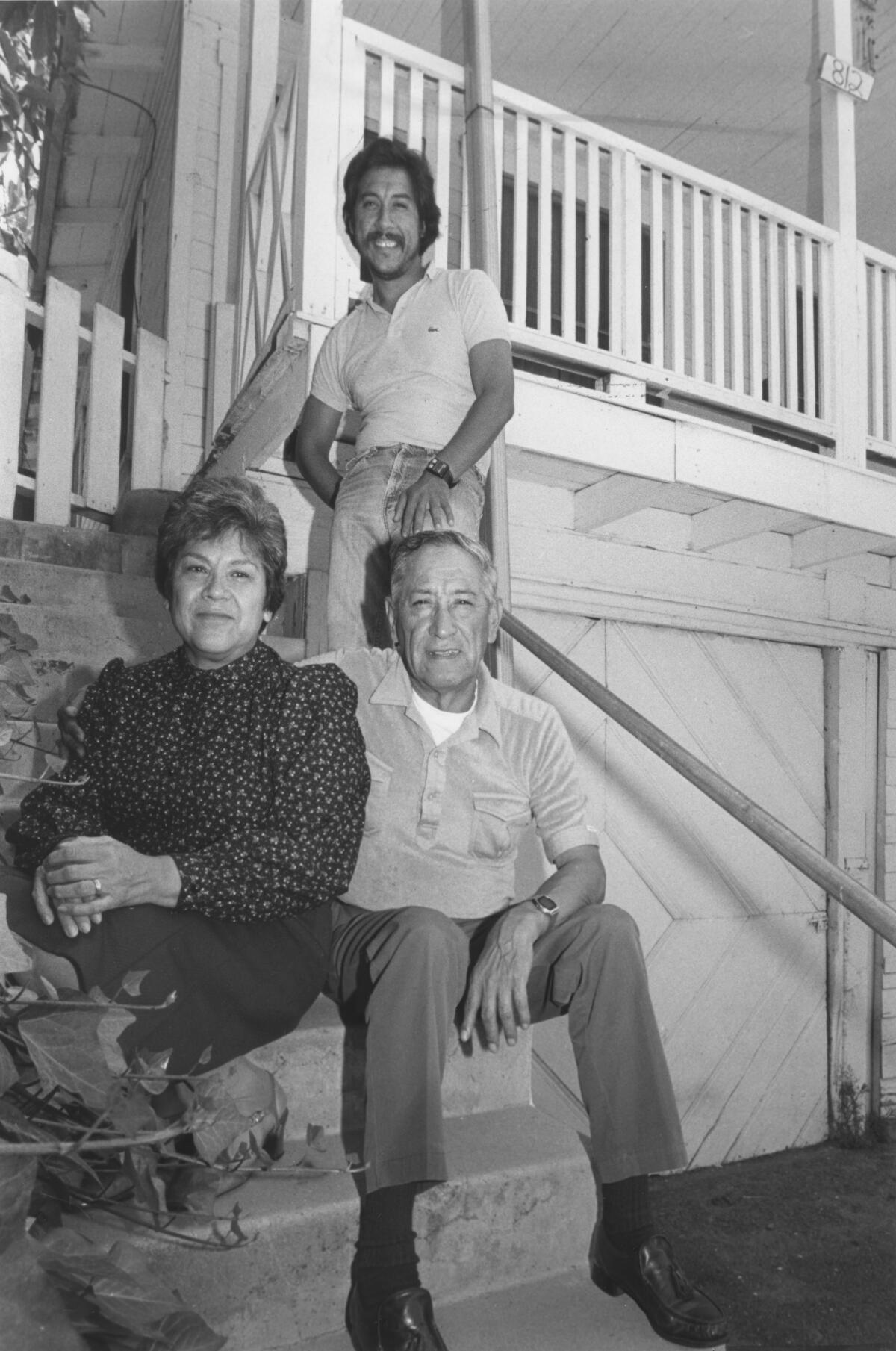 Times reporter George Ramos with his parents, Maria and Miguel, on the steps of the house where he grew up.