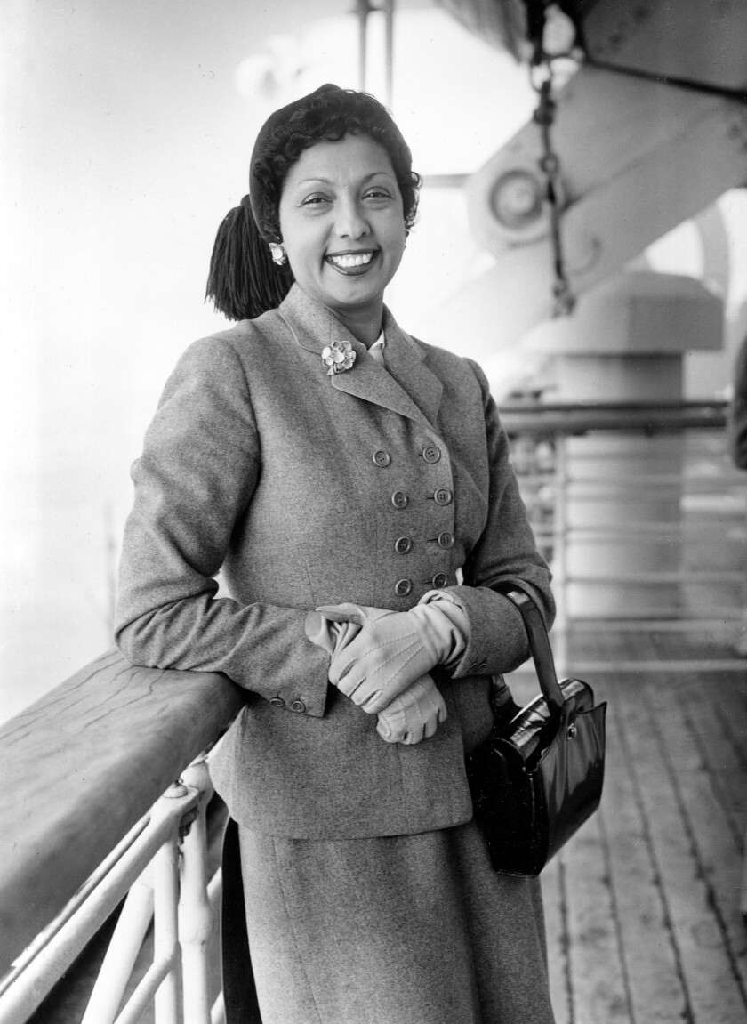 Josephine Baker leans against the railing on a sea liner