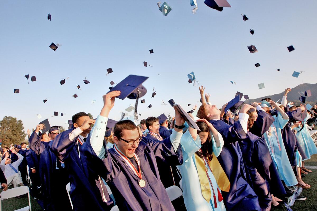 Crescenta Valley High graduates toss their caps into the air during their commencement ceremony on June 3, 2015. Enrollment is slightly down across Glendale schools, but district officials are optimistic that enrollment will "grow slightly" in the next two to three years.