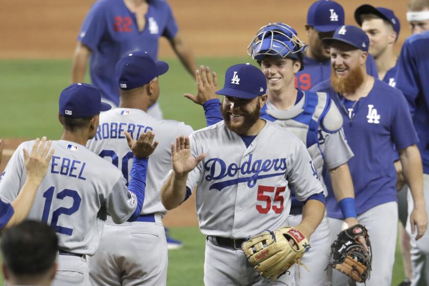 Los Angeles Dodgers catcher Russell Martin (55) high fives Dino Ebel (12) after a baseball game against the Miami Marlins, Tuesday, Aug. 13, 2019, in Miami. The Dodgers won 15-1. (AP Photo/Lynne Sladky)