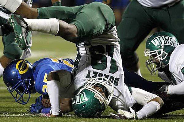 Dorsey defensive end Dwayne Reed goes head over heels after tackling Crenshaw running back Jacob Knight in the first quarter Thursday night at Crenshaw High. Dorsey would take a hard-earned 7-6 victory in the Coliseum League game.