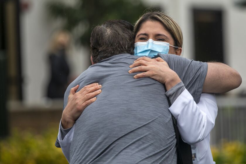 MISSION VIEJO, CA - DECEMBER 09: Dr. Shohreh Sameni, Hospitalist, right, hugs her former patient Paul Manzone, 46, left, at Providence Mission Hospital Mission Viejo on Thursday, Dec. 9, 2021 in Mission Viejo, CA. It was an emotional reunion of formerly hospitalized COVID patients and of their nurses, doctors and other caregivers mark the 50th anniversary of Providence Mission Hospital. Paul had been in the hospital for four months. (Francine Orr / Los Angeles Times)