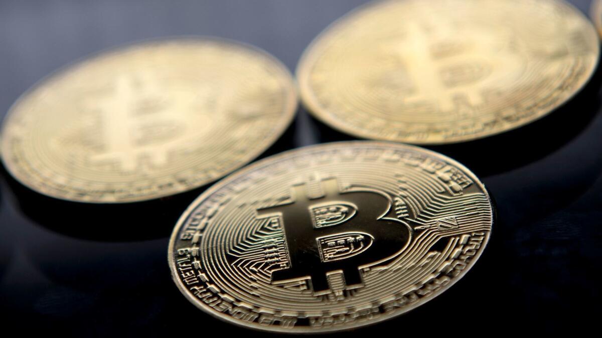 Regulators in several U.S. states and Canadian provinces are cracking down on cryptocurrency schemes. Above, tokens with the bitcoin logo.