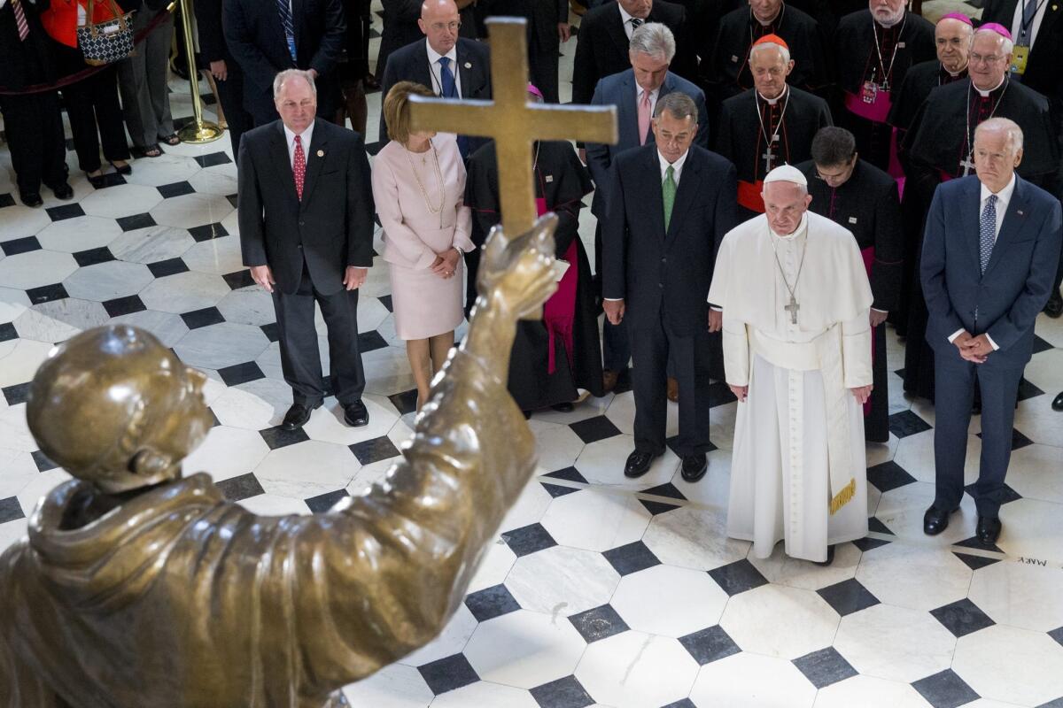 Pope Francis stands with U.S. Speaker of the House John Boehner, third from right, and Vice President Joe Biden right, before a sculpture of Spanish-born Junipero Serra, the Franciscan friar known for starting missions in California.