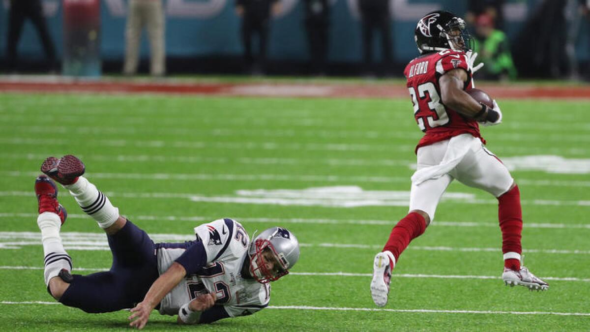 Patriots quarterback Tom Brady fails to tackle Falcons defensive back Robert Alford after he intercepted a pass during the second quarter.