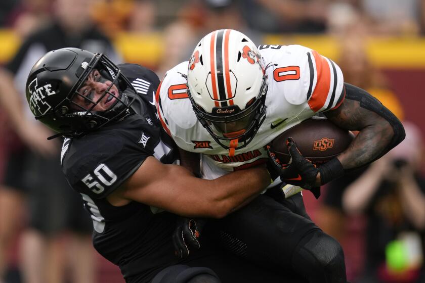 Oklahoma State running back Ollie Gordon II (0) is tackled by Iowa State linebacker Caleb Bacon (50) during the first half of an NCAA college football game, Saturday, Sept. 23, 2023, in Ames, Iowa. (AP Photo/Charlie Neibergall)