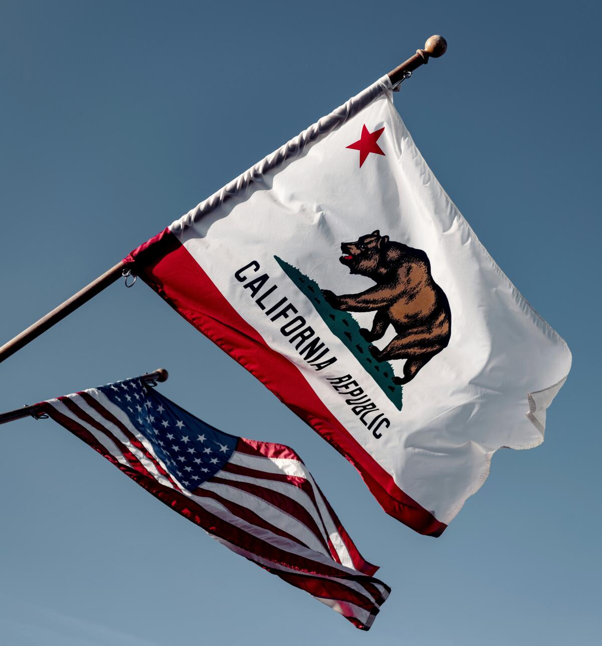 California's state flag flies next to the U.S. flag