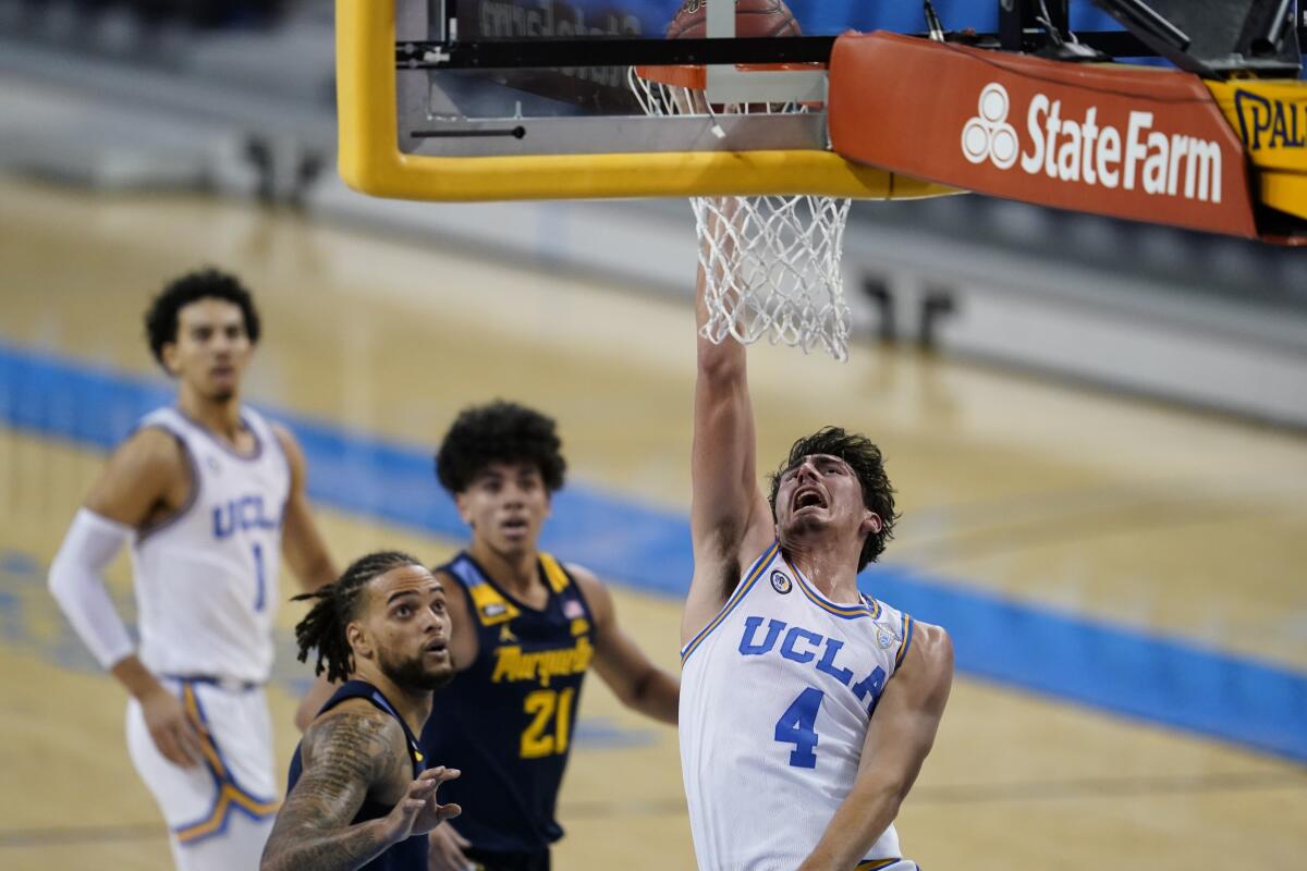 UCLA guard Jaime Jaquez Jr., right, puts up a shot in front of Marquette forward Theo John.