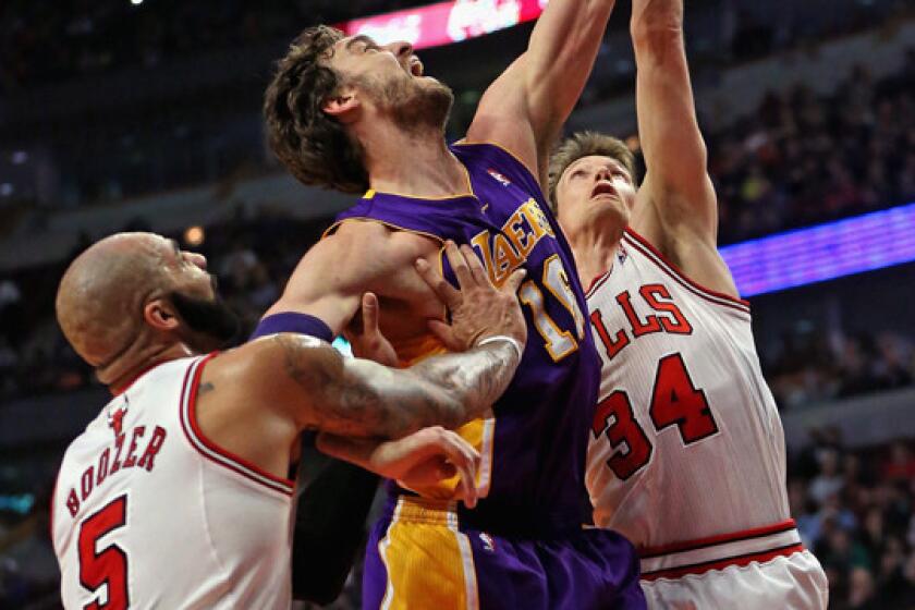 Lakers center Pau Gasol, middle, battles Chicago Bulls teammates Carlos Boozer, left, and Mike Dunleavy during the first half of the Lakers' 102-100 overtime loss Monday.