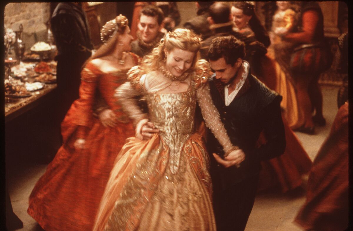 A man and woman dancing in ornate period costumes