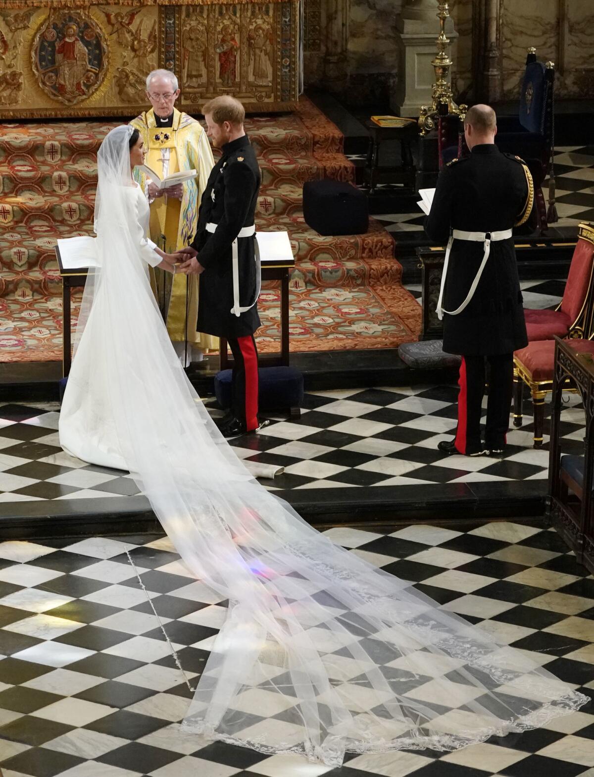 Prince Harry, the Duke of Sussex, and wife Meghan Markle, now the Duchess of Sussex, stand at the altar together before Archbishop of Canterbury Justin Welby in St. George's Chapel at Windsor Castle in England on Saturday during their wedding ceremony.