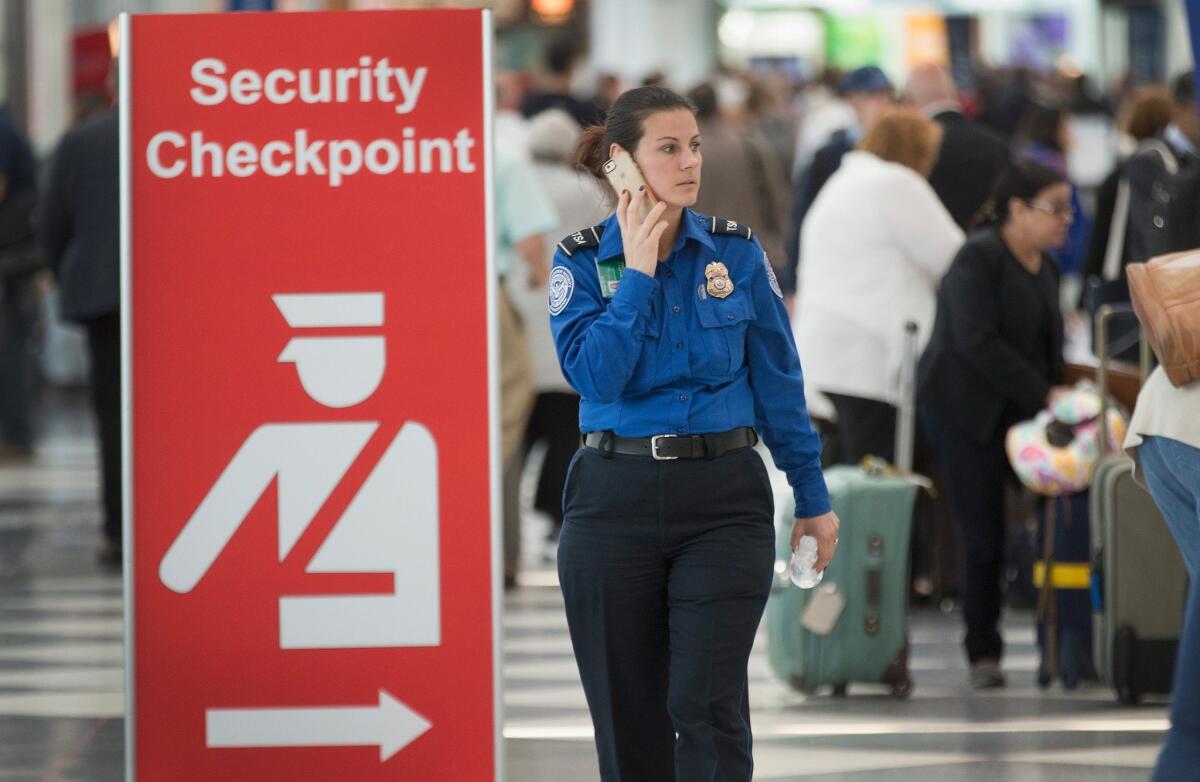 A sign directs travelers to a security checkpoint staffed by Transportation Security Administration workers at O'Hare Airport in Chicago.