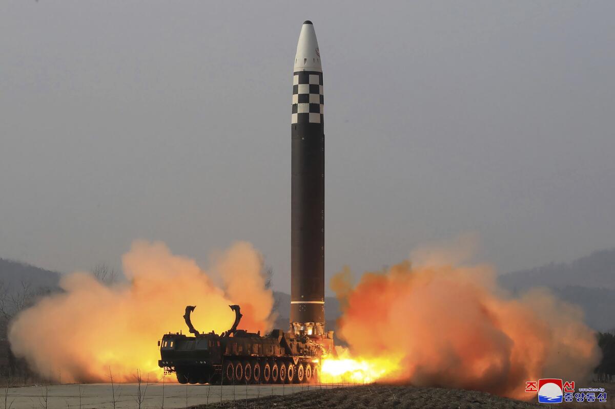 A large missile ignites before lifting off a launchpad