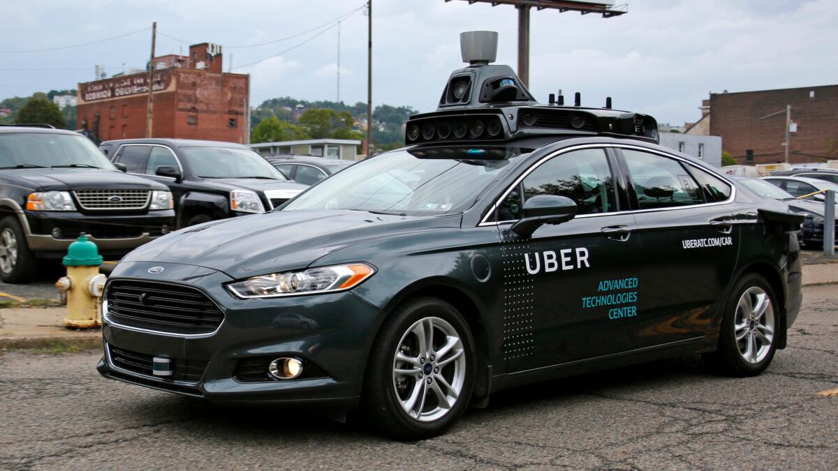 A self-driving Uber car makes its way down River Road in Pittsburgh.