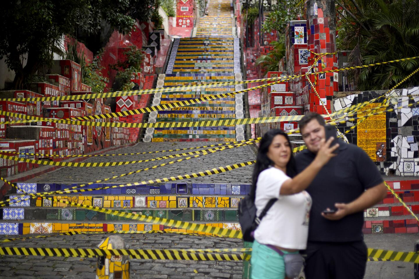 Brazil: Tourists pose for a photo in front of the sealed-off Selaron Steps during a lockdown aimed at stopping the spread of the coronavirus outbreak in Rio de Janeiro.