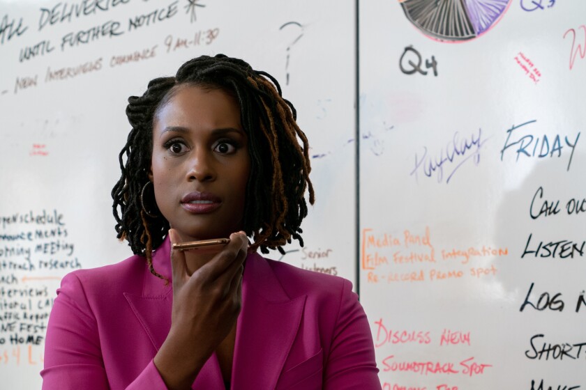 A woman with a phone in front of a whiteboard in the movie "Vengeance."
