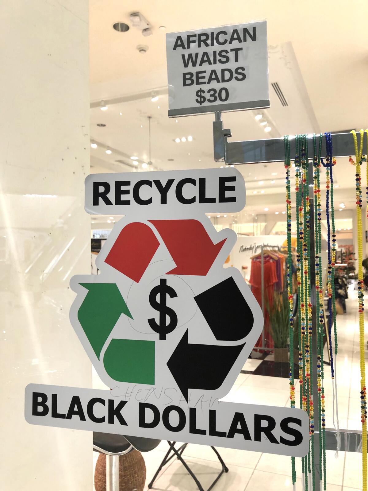 A "Recycle Black Dollars" sign greets those who pass by Afro City Marketplace at Baldwin Hills Crenshaw Plaza.