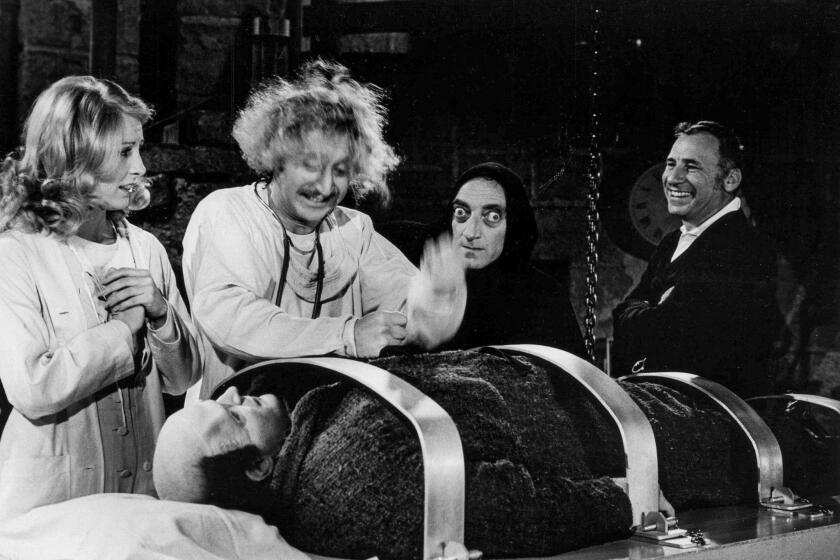 March 27, 1974: On the set of the movie "Young Frankenstein" are from left standing: Teri Garr, Gene Wilder, Marty Feldman, and Mel Brooks. Lying down is Peter Boyle as the Frankenstein monster.