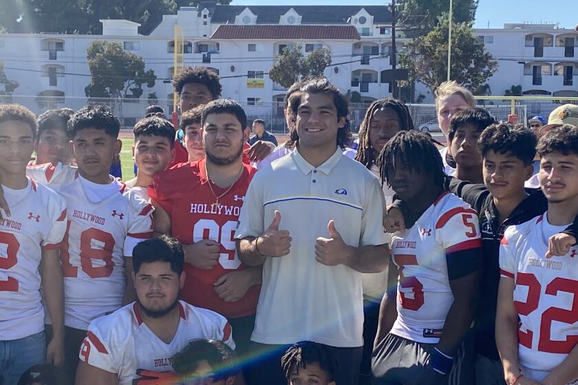 Rams rookie receiver Puka Nacua gives the thumbs among the football team when he visited Hollywood High earlier this season.