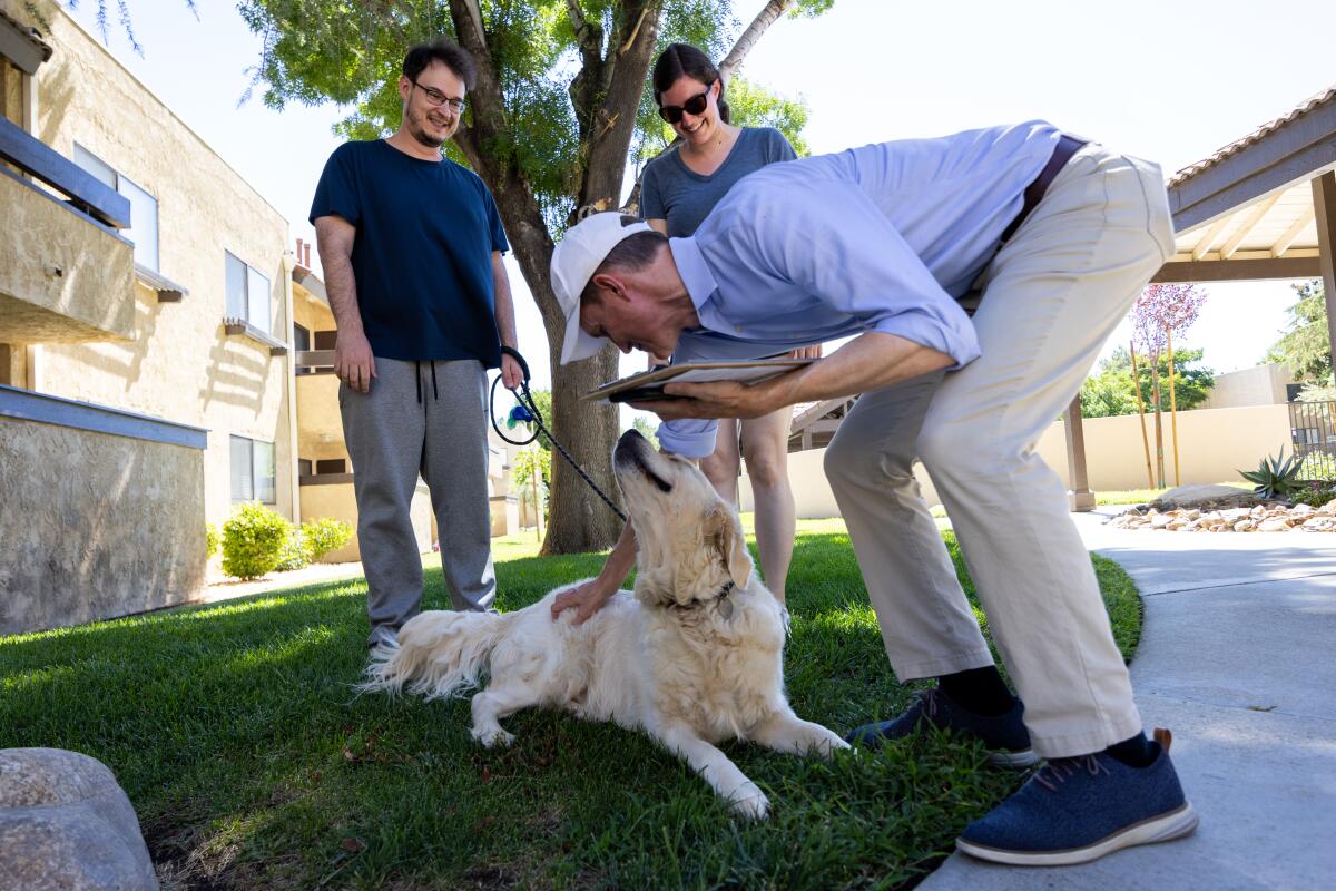 George Whitesides engages a couple and their golden retriever during a campaign stop. 
