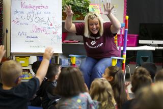 Ashley Leathers, a kindergarten teacher at at Reidy Creek Elementary School in Escondido, leads her class in song during the first day of the new school year.