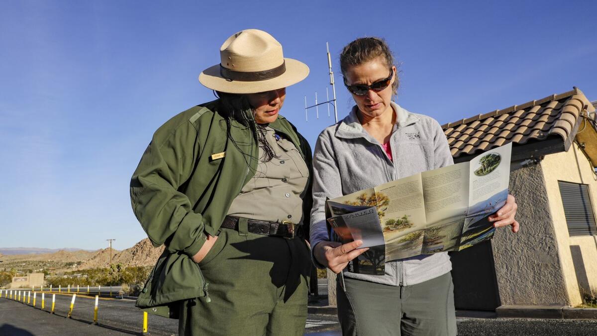 Park ranger Deann Casimiro, left, goes over directions with park visitor Mikal Lorio.