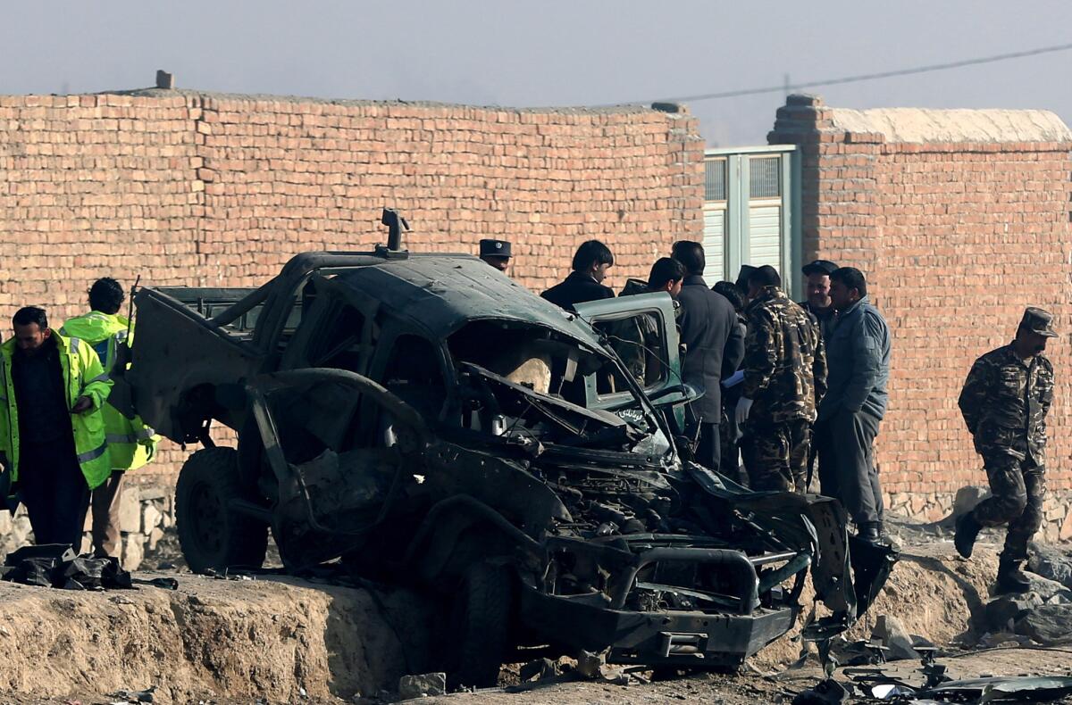 Afghan security forces inspect the site of a suicide attack that killed a police officer in Kabul on Dec. 18.