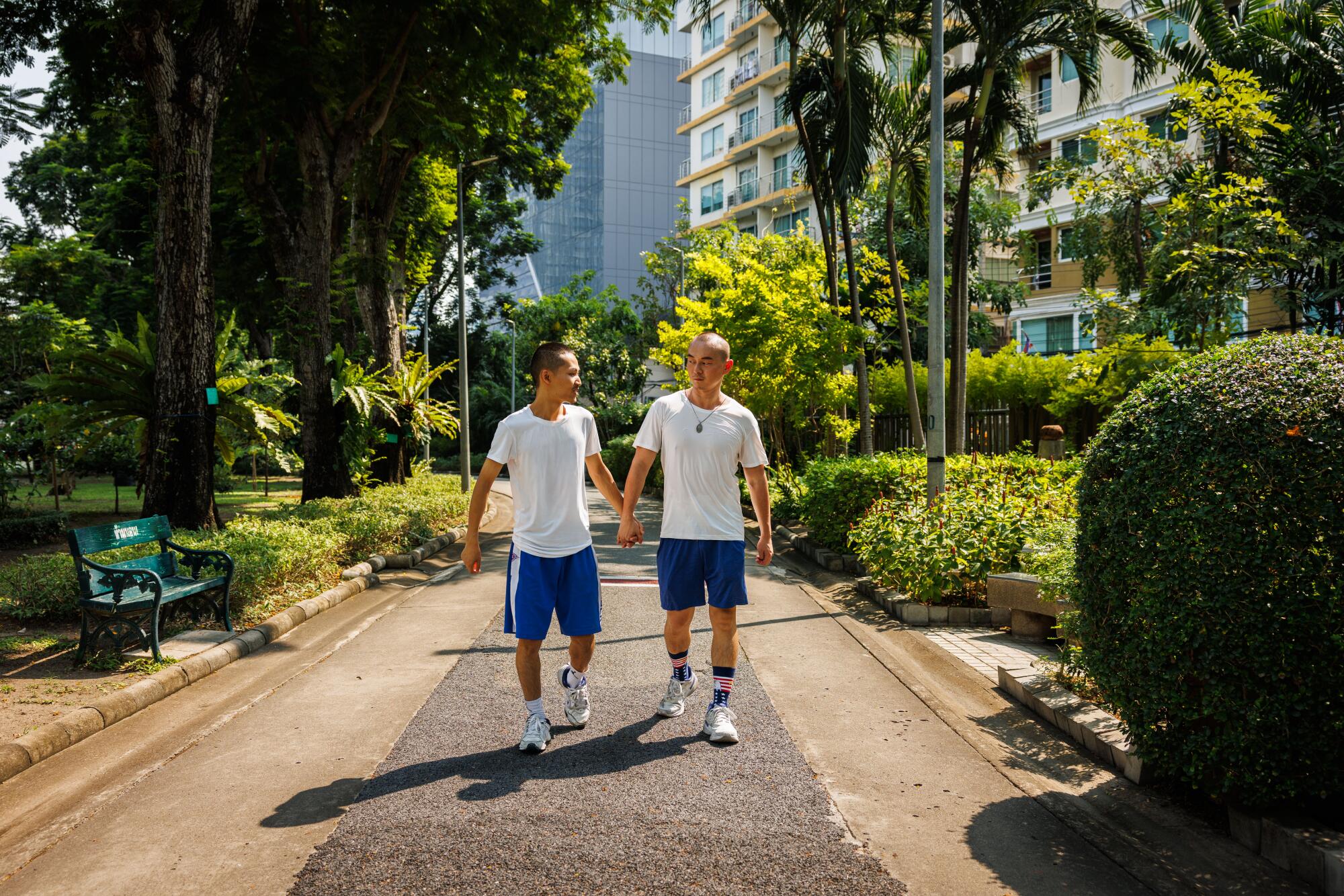 Wilfred Wu and Jeffery Hu walk through Santiphap Park after an outdoor workout on May 5, 
