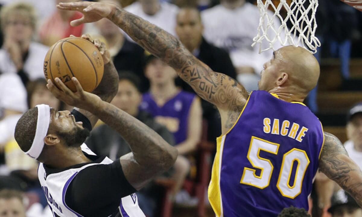 Lakers center Robert Sacre right, tries to block the shot of Sacramento Kings center DeMarcus Cousins during a game on Dec. 6.