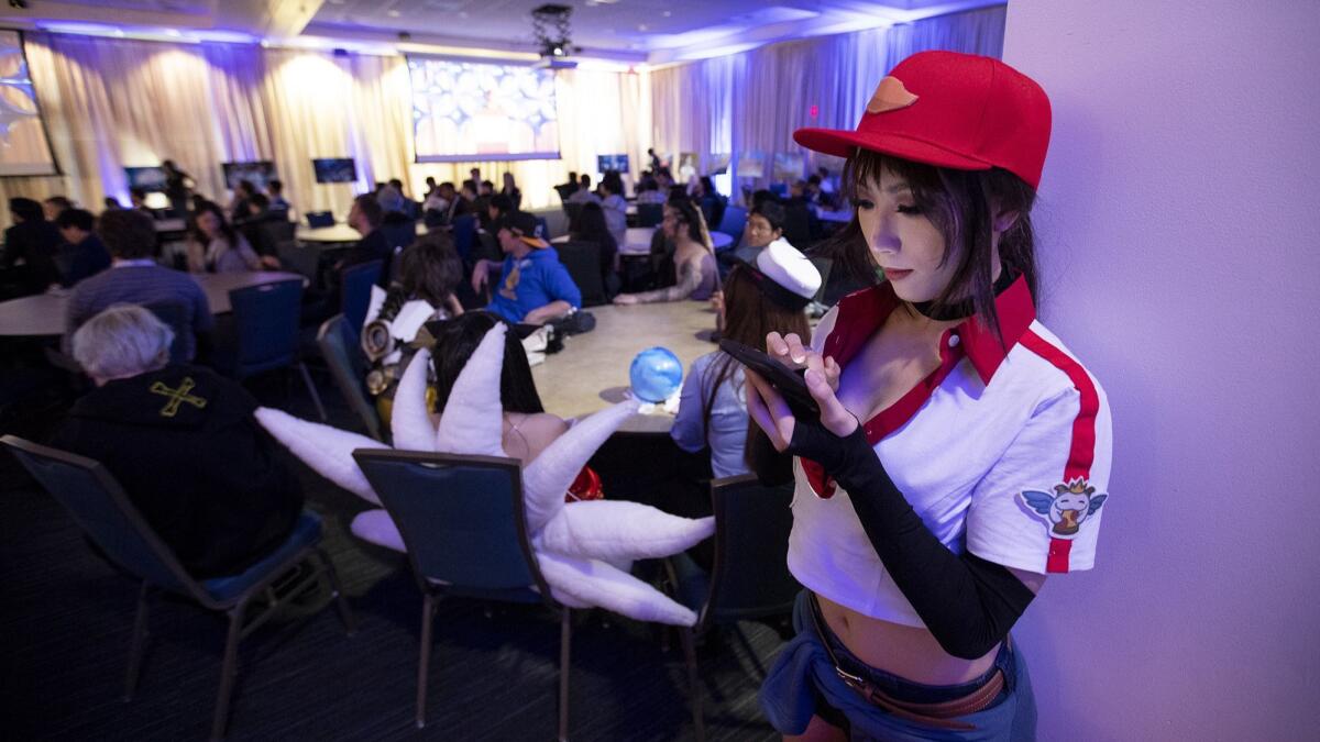 Lan Zhao, dressed as “Siver” from the game League of Legends, uses her phone during the keynote address at the Inven Global Esports Deep Dive conference at UCI on May 1.