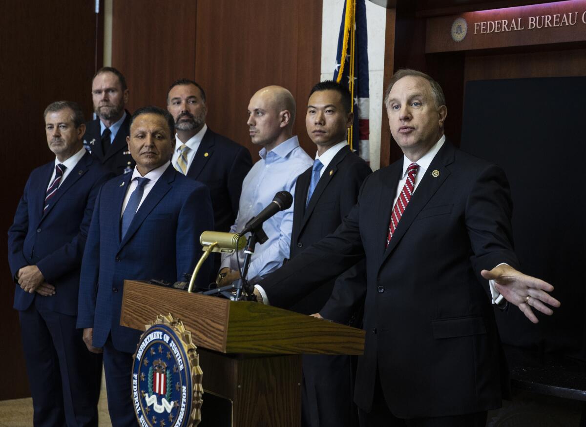 Special Agent in Charge Aaron Rouse of the FBI Las Vegas Field Office speaks as Acting U.S. Attorney Christopher Chiou, second right, looks on during a news conference at the FBI Las Vegas Field Office, Wednesday, July 14, 2021, in Las Vegas. U.S. officials declared they dismantled a key international cocaine and money-laundering hub in an ongoing investigation that began in Las Vegas and has involved at least 30 other countries. The top federal prosecutor and FBI chief in Las Vegas said the recent arrests of six people in Nevada, Arizona, California and Washington state came as part of the six-year probe. (Bizuayehu Tesfaye/Las Vegas Review-Journal via AP)
