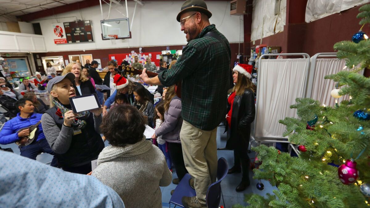 Pastor Ron Zimmer plays Christmas carols for those remaining at his shelter, East Avenue Church, in Chico. The shelter closed Friday.