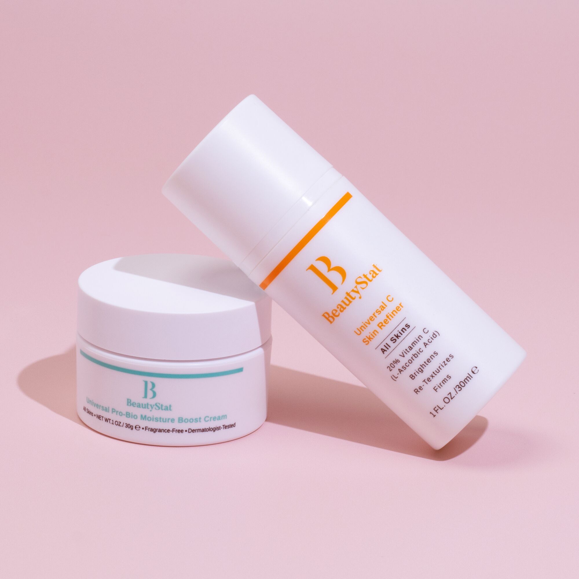 white BeautyStat skincare containers on a pink background