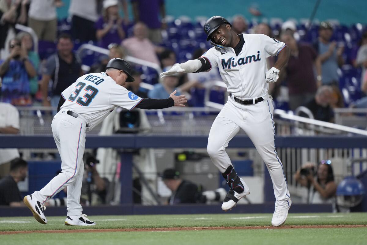 Miami Marlins' Jesus Sanchez celebrates with third base/infield coach Jody Reed after Sanchez hit a home run.