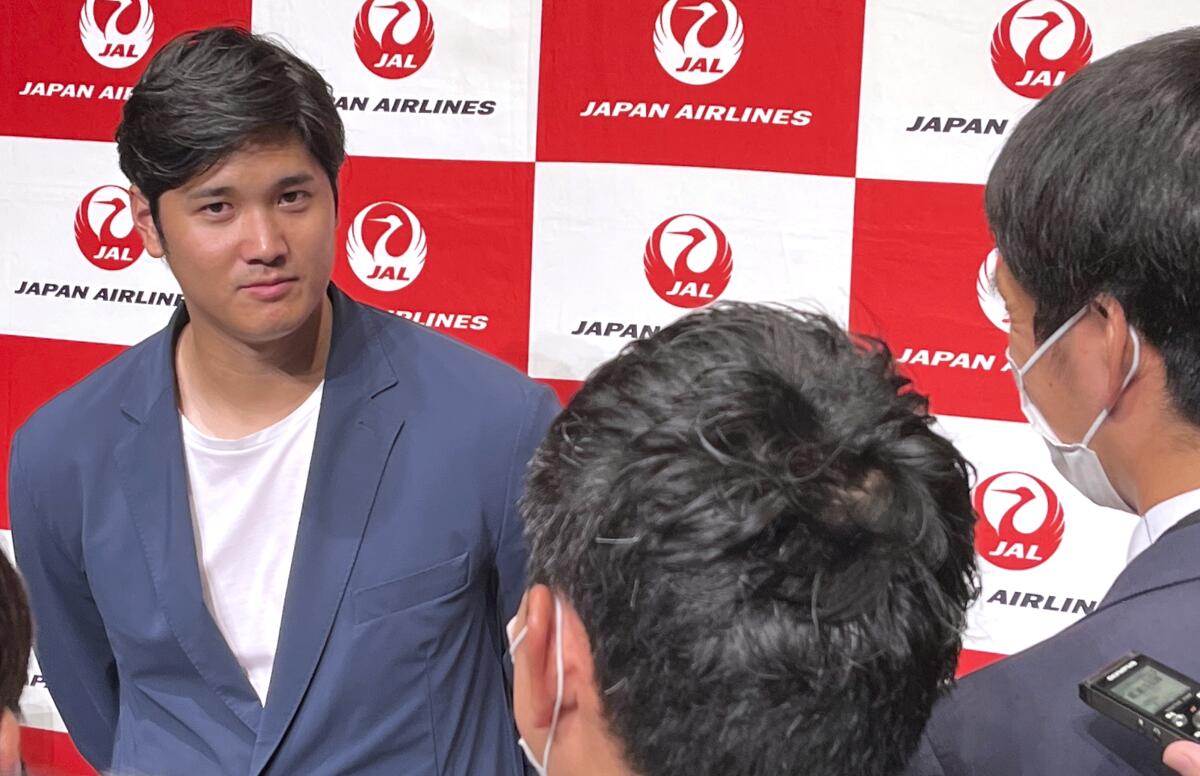 Angels' Shohei Ohtani speaks to reporters after he returned home at the Haneda international airport in Tokyo.