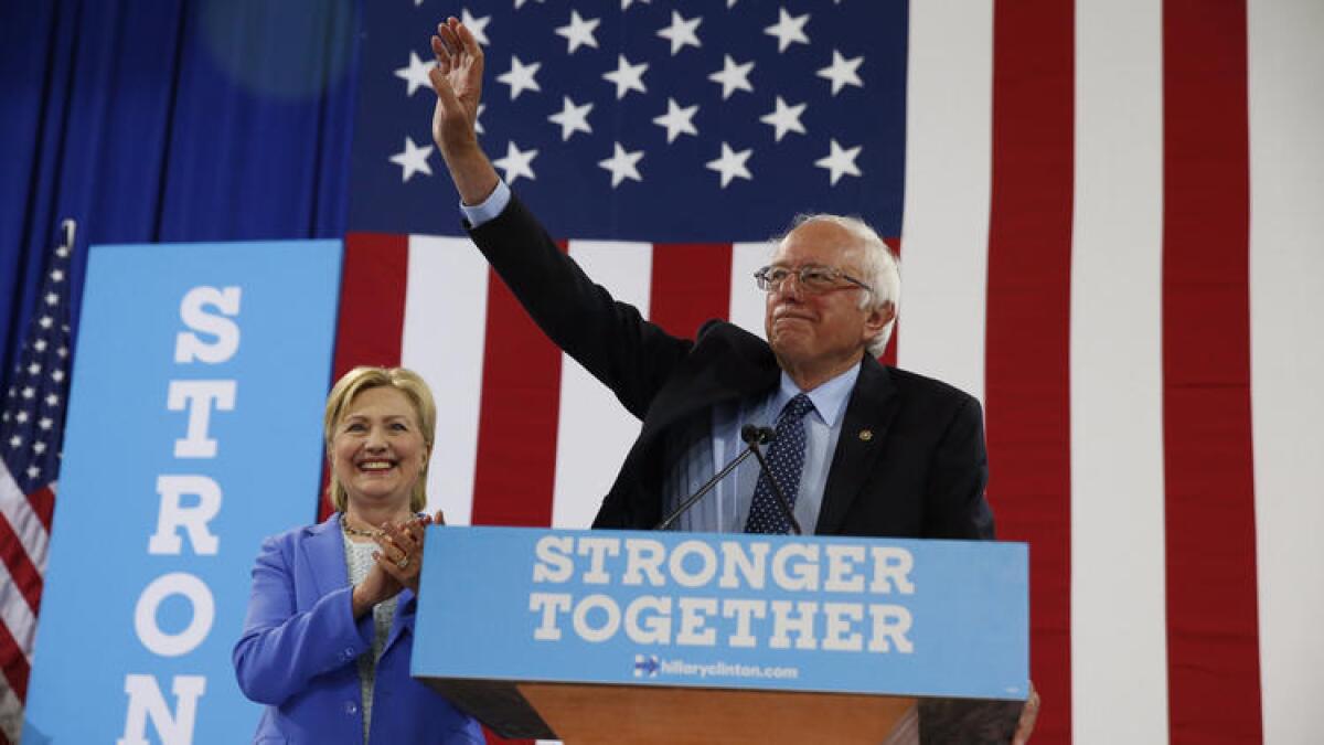 Sen. Bernie Sanders waves as he and Hillary Clinton arrive for a rally July 12 in Portsmouth, N.H.