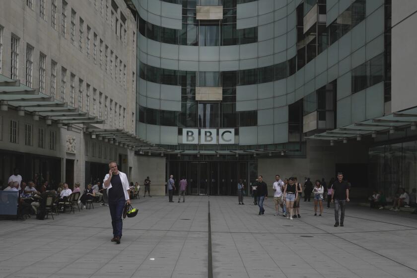 People walk outside the BBC Headquarters in London, Britain, Tuesday, July 11, 2023. British detectives met with representatives of the BBC on Monday over allegations that a leading presenter paid a teenager for sexually explicit photos. But police said they had not opened a criminal investigation, and a lawyer for the young person denied anything inappropriate had happened. (AP Photo/Kin Cheung)